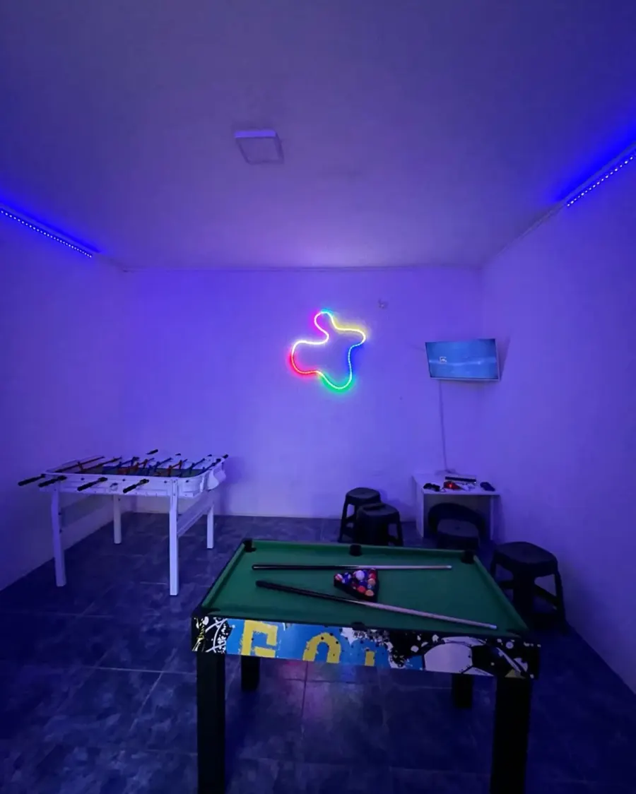 Mesa de pool y metegol con las luces violetas encendidas
